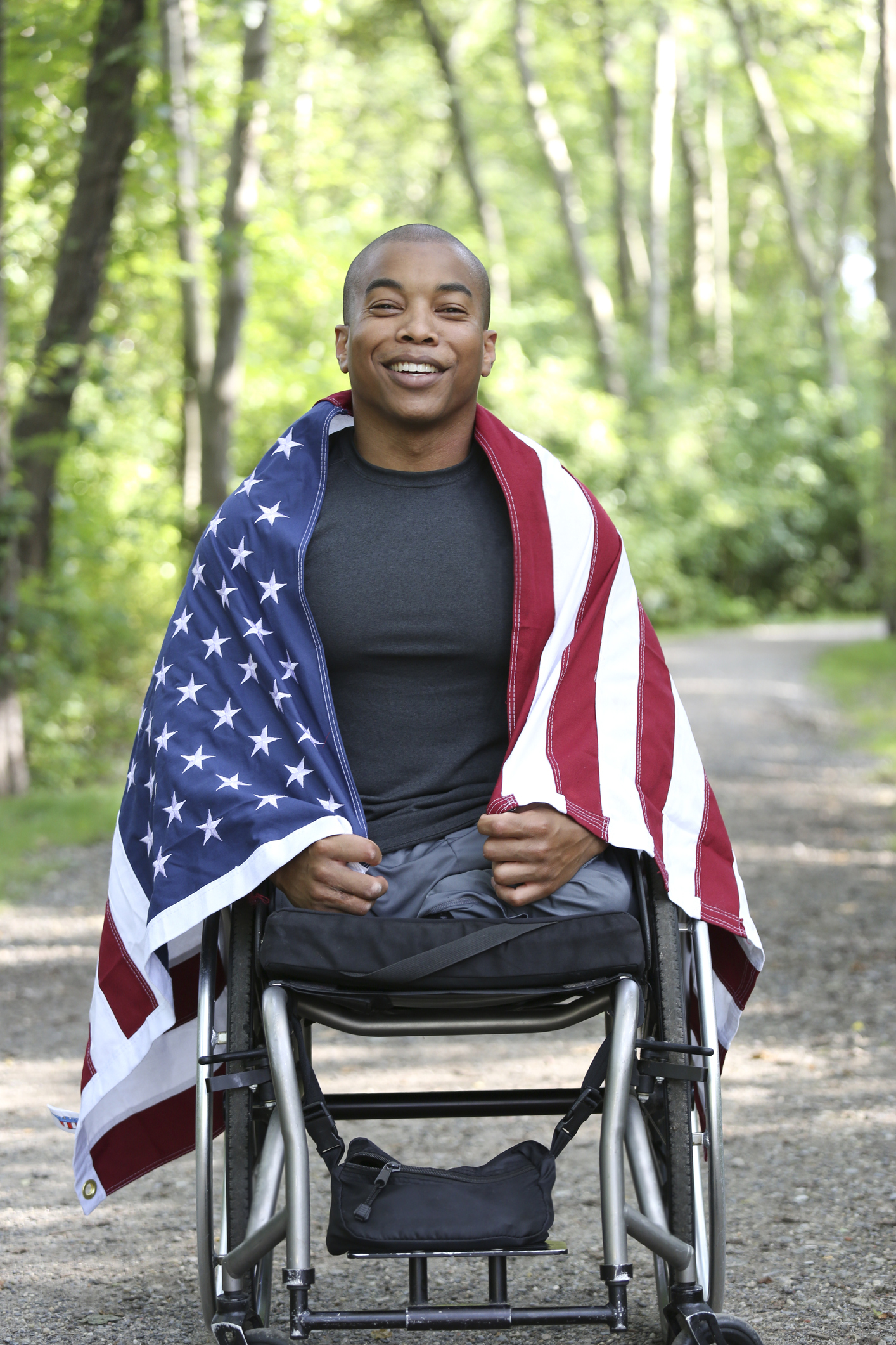 young amputee in wheelchair with american flag